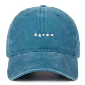 Close-up of white 'dog mum' embroidery on dark blue washed cotton baseball cap