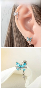 Close-up of butterfly cartilage earrings with marquise gems and dangling star pendants