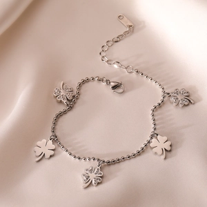 Silver four-leaf clover bracelet with sparkling cubic zirconia on soft silk background
