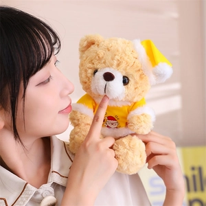 Detail showing a person holding a brown teddy bear in yellow Christmas outfit