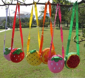 Detailed outdoor view of six assorted plush fruit-shaped shoulder bags for children