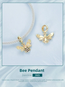 Macro view of gold plated S925 sterling silver bee charm with cubic zirconia wing details