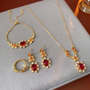Vintage-Schmuckset aus Gold mit roten Rubinen und Zirkonia auf grauem Samt im Detail