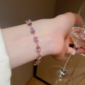 Detailed view of pink zircon gold bracelet with five oval stones on wrist