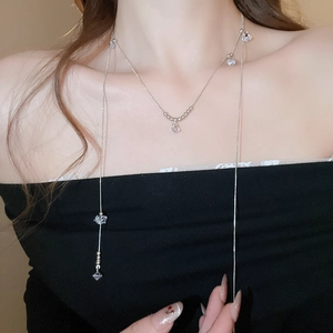 Long collier argenté avec pendentifs en zircon et perles sur un mannequin féminin