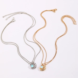 Detail view of gold and silver sun-moon projection necklaces with opal inlay