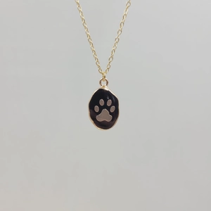 Detail of gold stainless steel necklace with black oval paw print pendant and O-chain