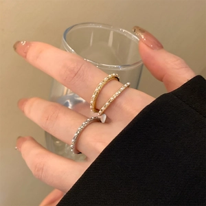 Close-up of 14K gold plated pearl and zircon rings worn on fingers with a minimalist design