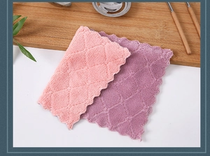 Macro detail of pink and purple microfiber kitchen cloths with wave edges on a wooden board