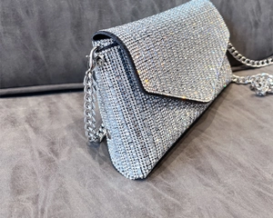 Macro shot of silver rhinestone evening bag with luxury chain strap and sparkling crystals