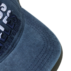 Detailed close-up of vintage denim texture and high-quality 3D embroidery on the baseball cap
