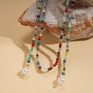 Detail of colorful glass beads and large white pearls on a bohemian layered necklace