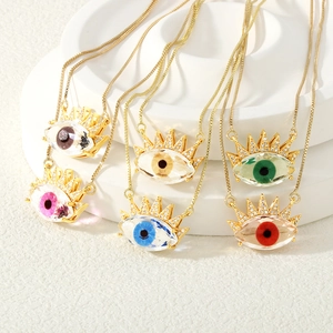 Detail view of colorful evil eye pendants with zircon accents on gold necklaces