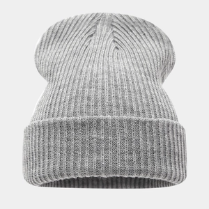 Détail du bonnet en tricot gris montrant la texture à rayures verticales et le revers