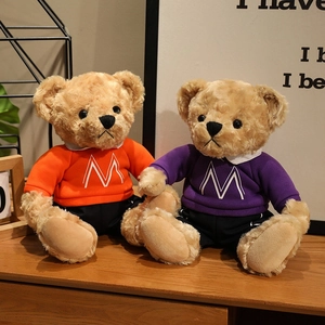 Plush teddy bears in orange and purple college style sweaters with M letter embroidery