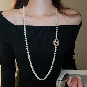 Vue détaillée du collier de perles multicouche avec pendentif fleur dorée sur modèle