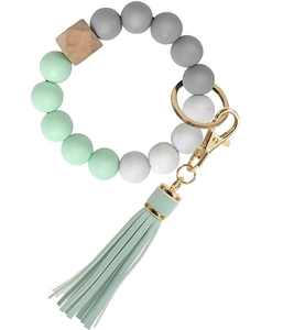 Detail of mint green silicone beaded wristlet with tassel and natural wooden hexagon bead