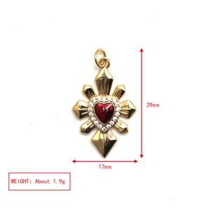 Detail shot of golden cross heart pendant with red stone and dimensions 29mm x 17mm