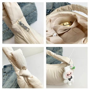 Detail view of cream quilted bag with knot handle, inner zipper pocket, and bunny charm