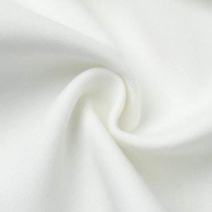 Close-up of white twill fabric texture with soft glossy finish on a lace blazer