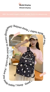 Detailed view of black canvas backpack featuring cute white bear and red polka dot prints
