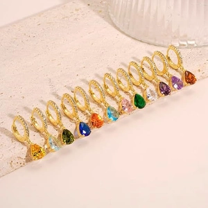 Colorful zircon water drop earrings in various shades on textured stone background