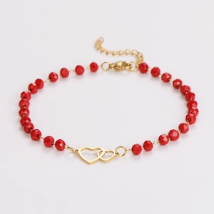 Detail of red faceted bead bracelet featuring golden interlocking hearts and lobster clasp