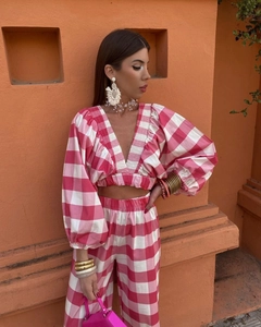 Detail of pink plaid V-neck cropped top with ruffled edges and puff sleeve design