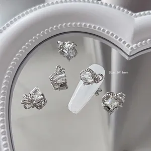 Vue macro de bijoux d'ongles en nœud argenté avec zircon carré, taille 9x11mm sur ongle