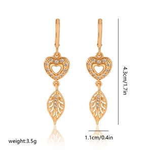 Detailed view of heart and leaf earrings with champagne gold plating and white zircon