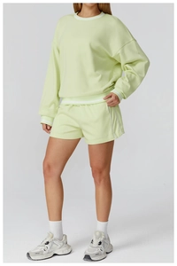 Détail d'un ensemble de jogging vert clair avec rayures blanches et texture tricot
