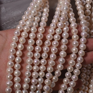 Strands of 7mm creamy white near-round freshwater pearls with high luster on grey silk