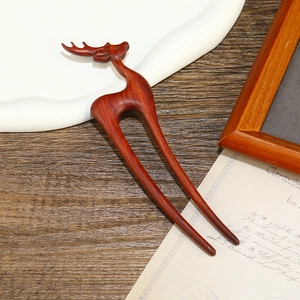 Detail of red sandalwood hair pin featuring a hand-carved deer shape with natural wood grain