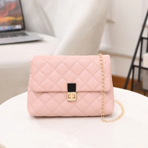 Pink quilted leather crossbody bag with gold chain strap and turn-lock closure on marble table