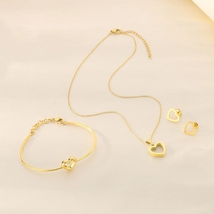 Détails d'un ensemble de bijoux cœur doré avec collier, bracelet et boucles d'oreilles