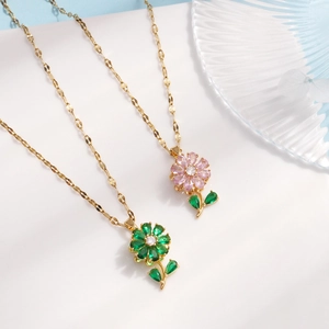 Elegant gold flower necklaces with green and pink zircon pendants on a white background