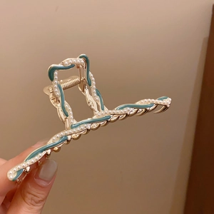 Elegant gold metal wave hair claw with teal enamel and pearl trim for bun hairstyles
