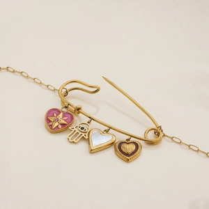 Detail of gold paperclip pendant with pink enamel heart and Fatima hand charms