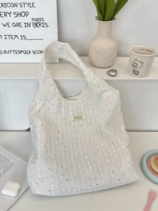 White sequined canvas tote bag with shoulder straps for women in a minimalist desk setting