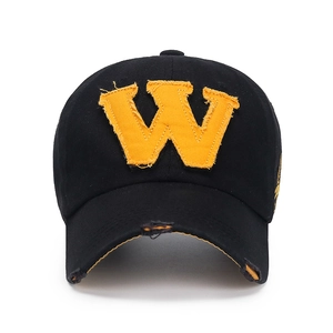 Vintage black baseball cap with yellow letter W patch and distressed ripped brim
