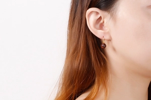 Close-up of faceted reddish-brown crystal bead pendant with golden stainless steel hook