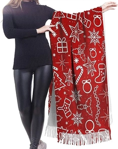 Detail of red Christmas scarf featuring white snowflake patterns and elegant fringe trim