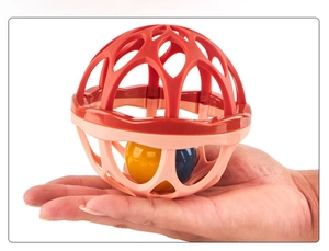 Close-up of a double-layered baby sensory rattle ball with colorful inner spheres