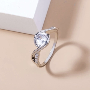 Detailed view of silver ring featuring a large round clear gem and twisted pavé band