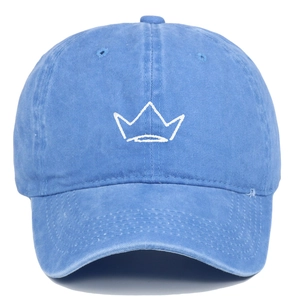 Detailed view of white crown embroidery on vintage washed blue cotton baseball cap