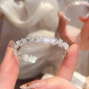 Close-up of hollow flower pattern on silver-plated open cuff bracelet for women