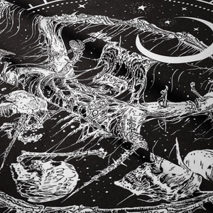 Close-up of gothic tapestry fabric showing black and white skull and crescent moon patterns