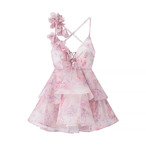Detail van roze organza jurk met 3D-bloemenaccenten en gelaagde ruches op de rok