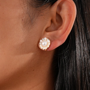Close-up of floral clip earring with pearls and rhinestones on woman's ear