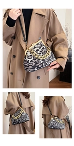 Detail of leopard print shell bag with thick gold chain and crossbody strap styling